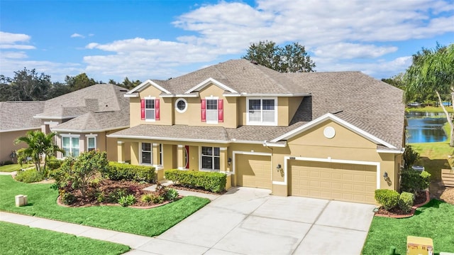 view of front facade with a water view, a front lawn, and a garage