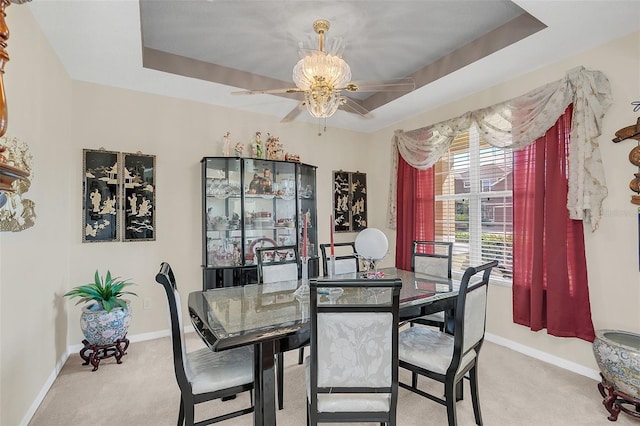 dining room featuring light carpet and a tray ceiling