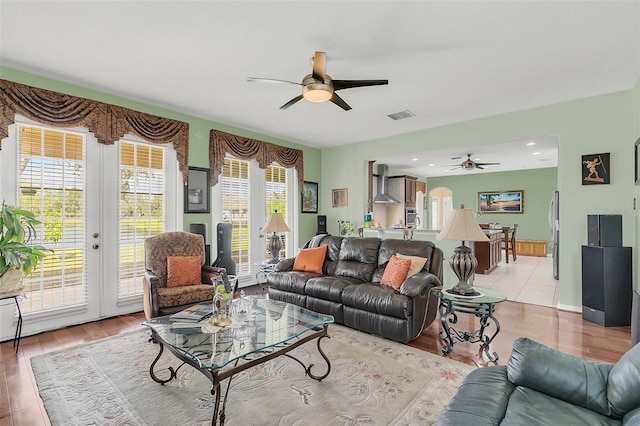 living room featuring french doors, ceiling fan, and light hardwood / wood-style flooring