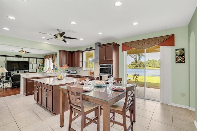 kitchen featuring kitchen peninsula, a healthy amount of sunlight, light stone counters, and a kitchen island