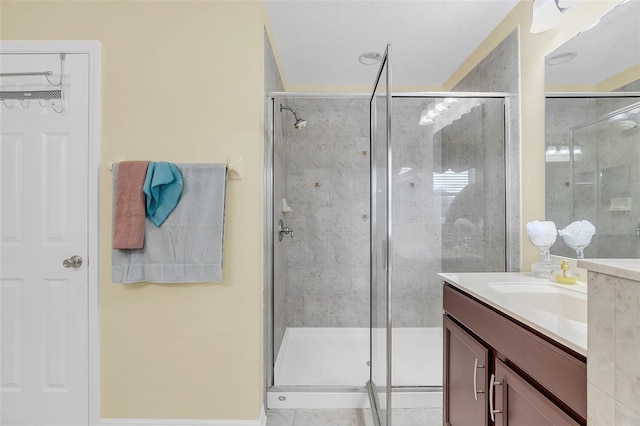 bathroom with vanity, an enclosed shower, and a textured ceiling