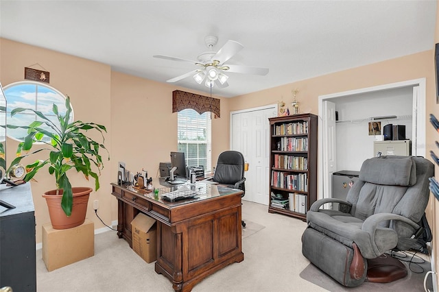 carpeted office space featuring ceiling fan