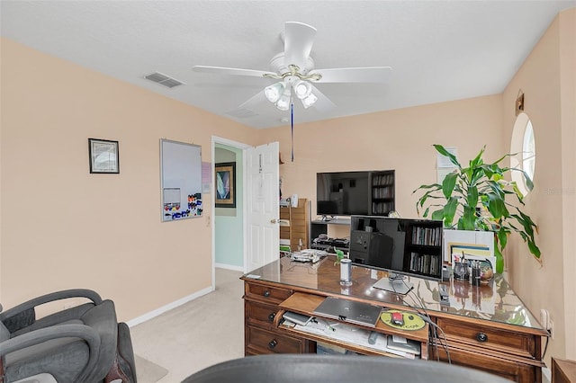 carpeted home office featuring a textured ceiling and ceiling fan