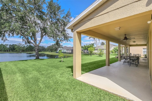 view of yard with a patio, a water view, and ceiling fan