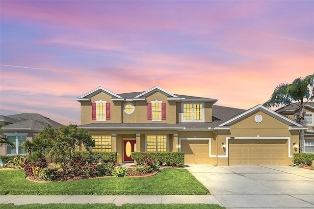 view of front of property with a garage and a lawn