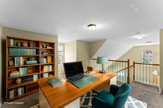 office area featuring vaulted ceiling, visible vents, and carpet floors