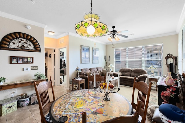 tiled dining room featuring crown molding and ceiling fan