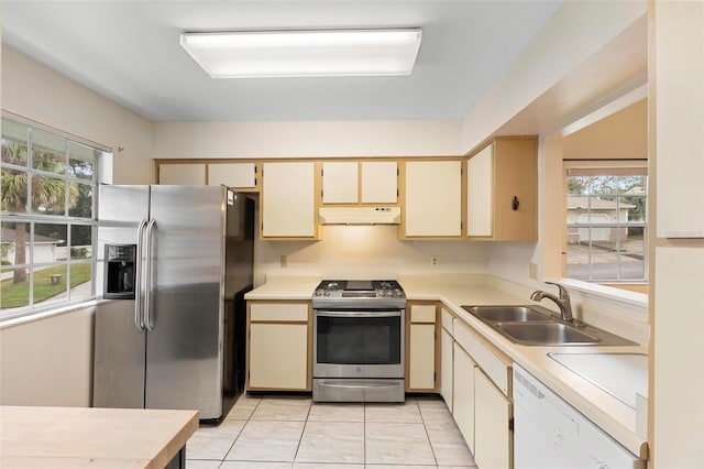 kitchen featuring a healthy amount of sunlight, appliances with stainless steel finishes, sink, and cream cabinetry