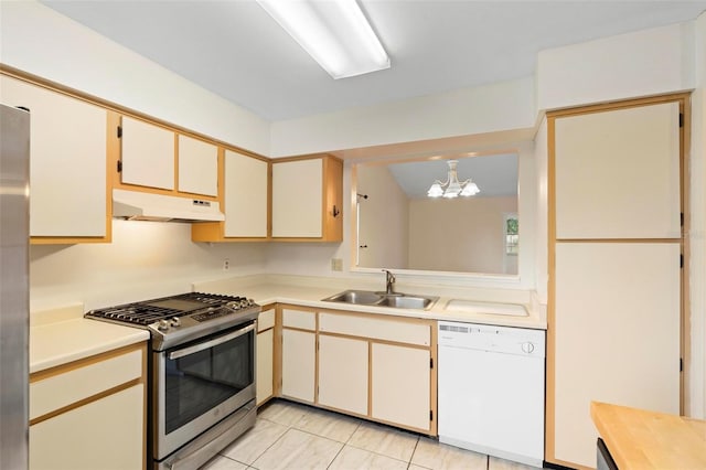 kitchen with stainless steel appliances, hanging light fixtures, a notable chandelier, sink, and light tile patterned floors