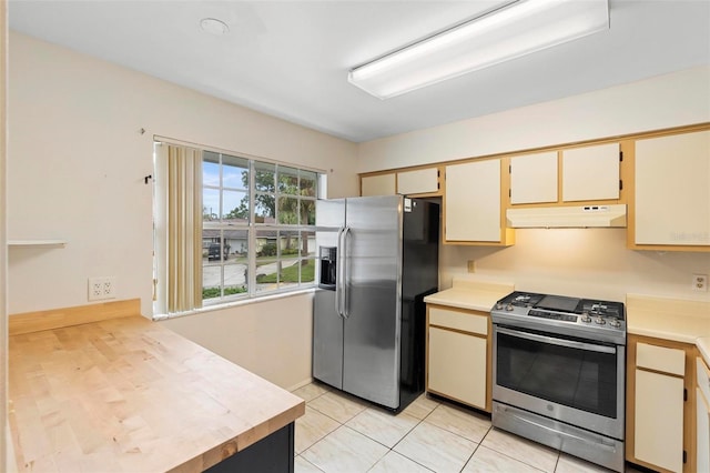 kitchen featuring appliances with stainless steel finishes, cream cabinets, and light tile patterned floors