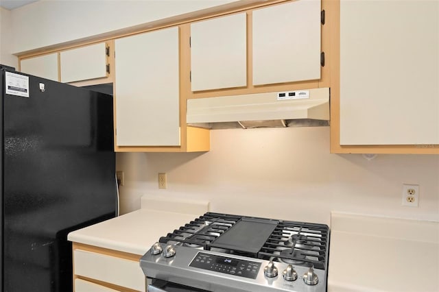 kitchen with stainless steel stove and black fridge