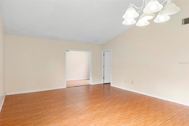 spare room featuring lofted ceiling and a notable chandelier