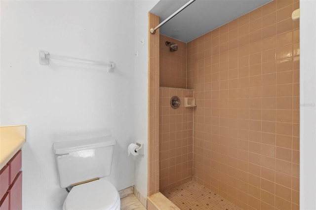 bathroom featuring toilet, vanity, and a tile shower