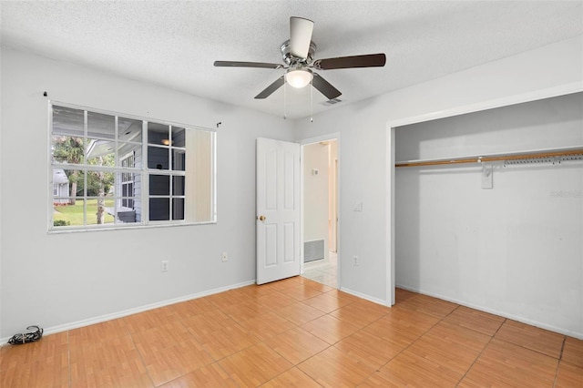 unfurnished bedroom with a textured ceiling, hardwood / wood-style flooring, ceiling fan, and a closet