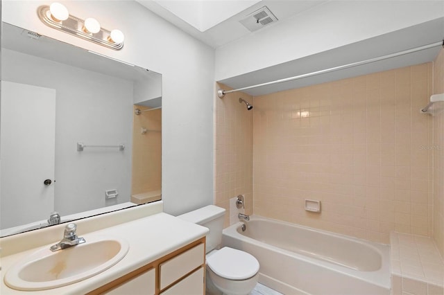 full bathroom featuring vanity, tiled shower / bath combo, and toilet