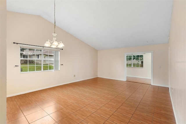 spare room featuring a chandelier, a wealth of natural light, and lofted ceiling