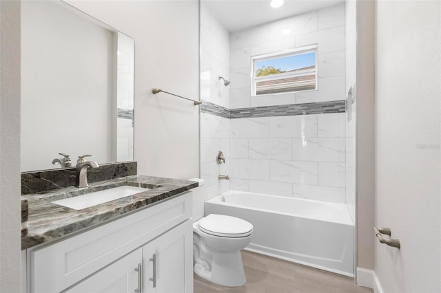 full bathroom featuring wood-type flooring, vanity, toilet, and tiled shower / bath