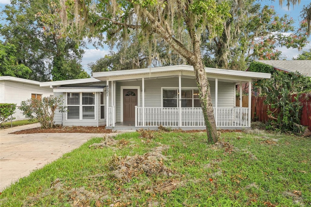 single story home with a porch and a front lawn