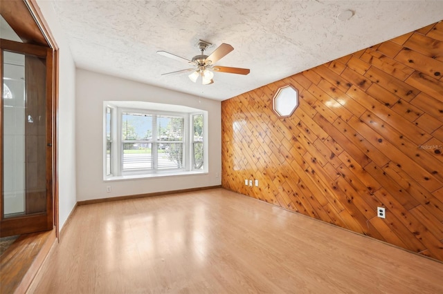 4221 Mizell St, Orlando, FL 32812 - spare room with a ceiling fan, baseboards, wood walls, and a textured ceiling