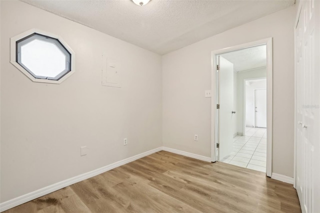 4221 Mizell St, Orlando, FL 32812 - empty room featuring baseboards, light wood finished floors, and a textured ceiling