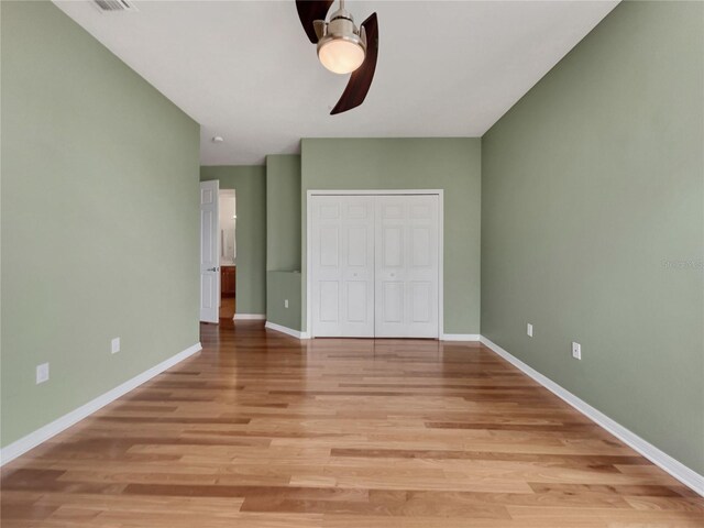 unfurnished bedroom featuring light hardwood / wood-style flooring, a closet, and ceiling fan