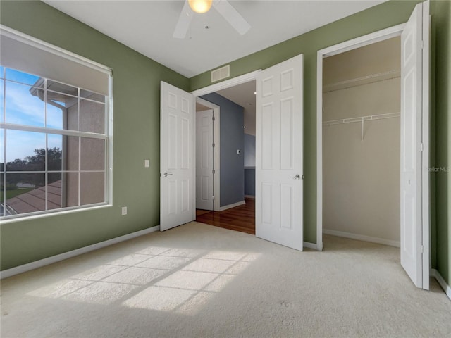 unfurnished bedroom with light colored carpet, a closet, and ceiling fan