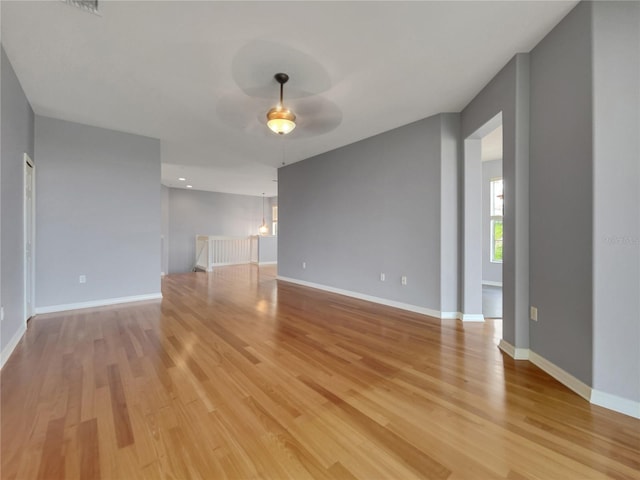 empty room with ceiling fan and light wood-type flooring