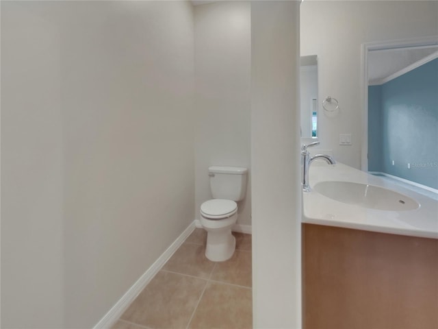 bathroom with toilet, ornamental molding, vanity, and tile patterned flooring