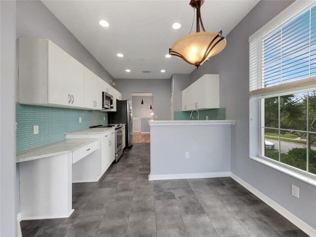 kitchen featuring white cabinets, backsplash, sink, pendant lighting, and stainless steel appliances