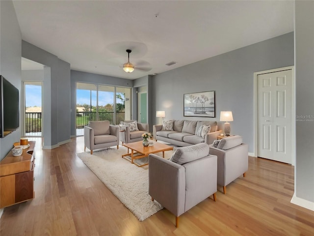 living room featuring light hardwood / wood-style flooring and ceiling fan