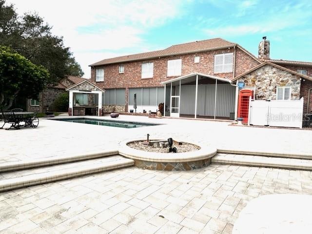 back of property featuring a sunroom and a patio