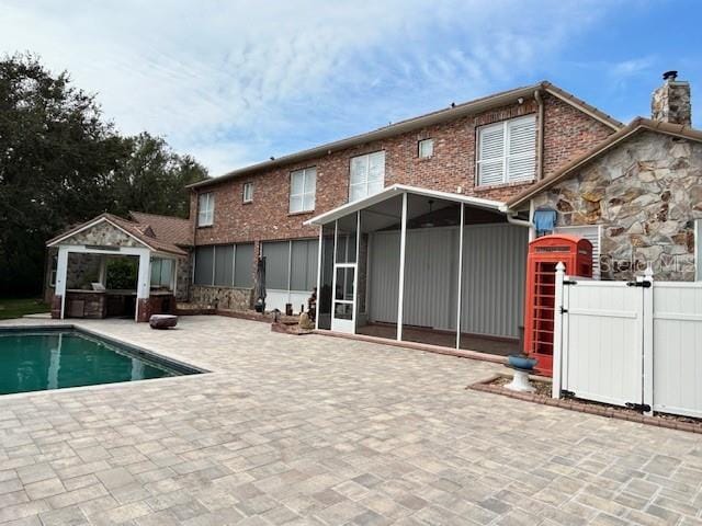 back of house featuring a patio and a sunroom