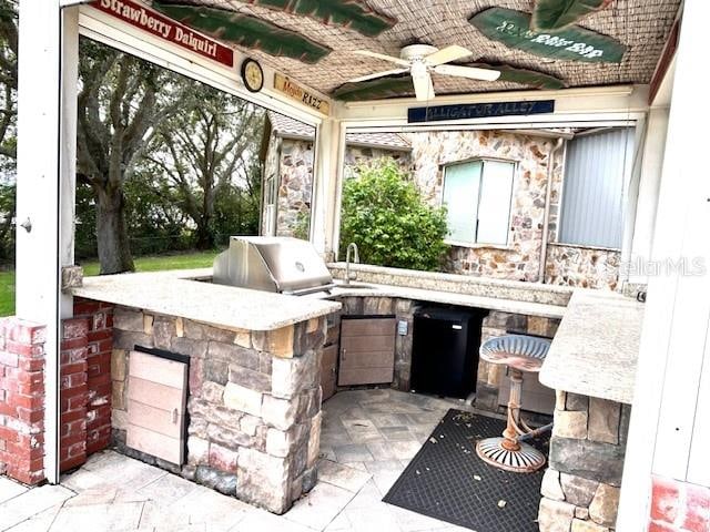 view of patio featuring a grill, area for grilling, ceiling fan, and sink