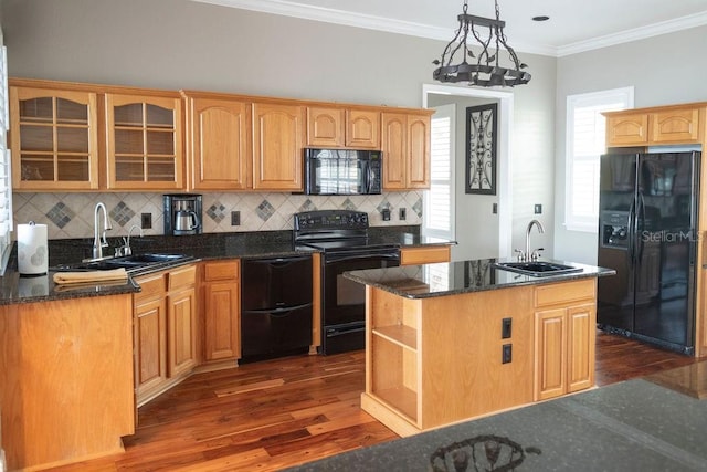 kitchen with pendant lighting, sink, a center island with sink, and black appliances