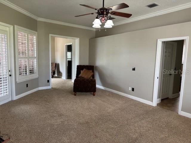 unfurnished room with ceiling fan, light colored carpet, and crown molding