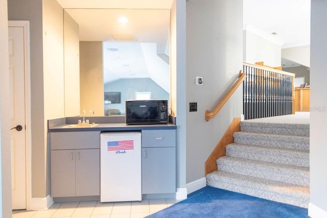 staircase featuring tile patterned flooring and wet bar