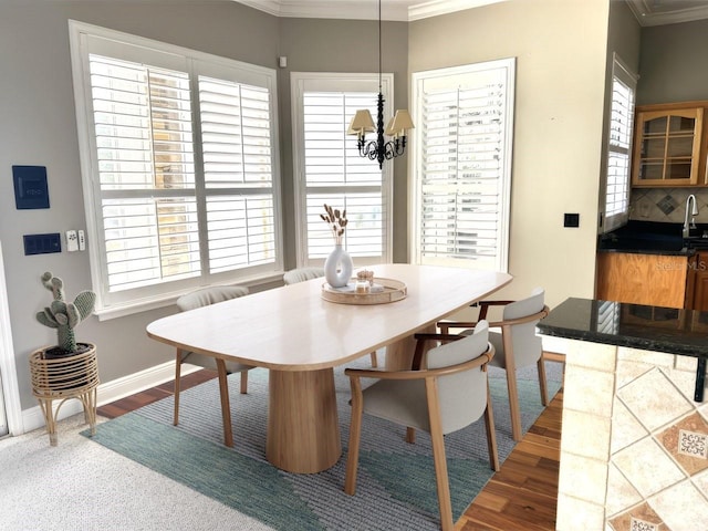 dining area featuring dark wood-type flooring, an inviting chandelier, and ornamental molding