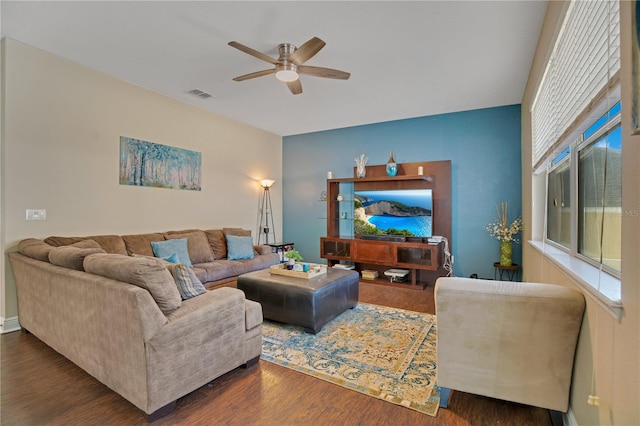 living room featuring ceiling fan and dark hardwood / wood-style floors