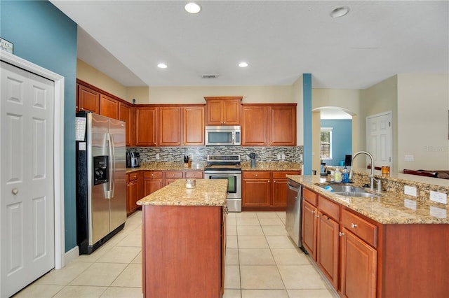 2053 Nobscot Pl, Apopka, FL 32703 - kitchen featuring arched walkways, a kitchen island with sink, appliances with stainless steel finishes, and a sink