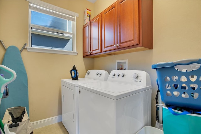 washroom with washer and clothes dryer, light tile patterned flooring, and cabinets