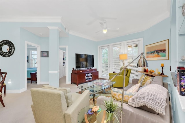 living room with ornate columns, light carpet, crown molding, and ceiling fan