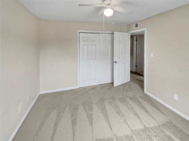 unfurnished bedroom featuring light carpet, a closet, and ceiling fan