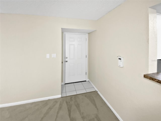 doorway featuring a textured ceiling and light colored carpet