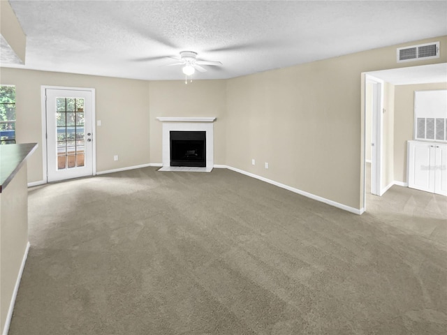 unfurnished living room with carpet floors, a textured ceiling, and ceiling fan