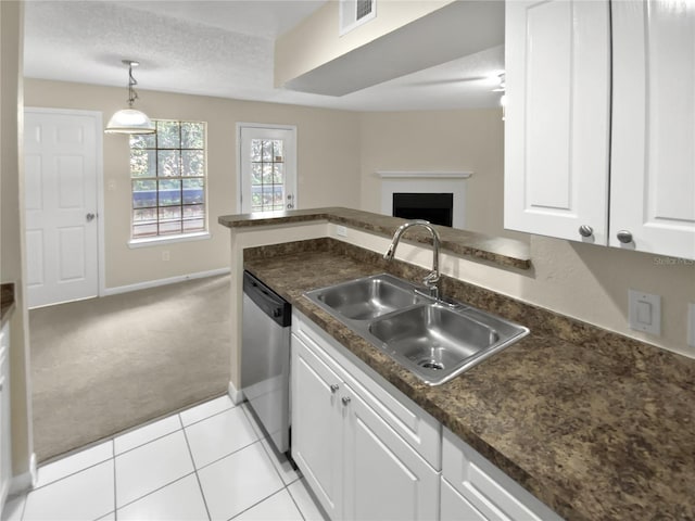 kitchen with dishwasher, light carpet, sink, white cabinets, and a textured ceiling