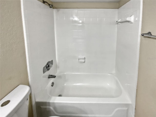 bathroom featuring tiled shower / bath and toilet