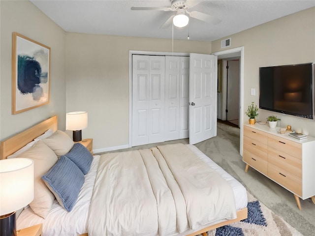 bedroom with a closet, light colored carpet, and ceiling fan