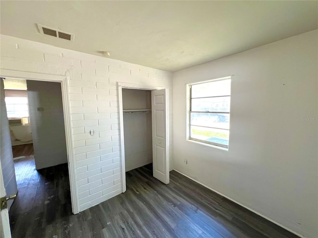 unfurnished bedroom with a closet and dark hardwood / wood-style floors