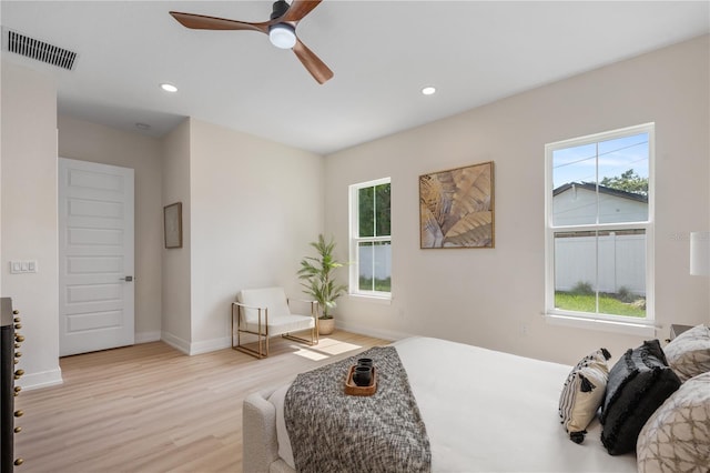 bedroom with multiple windows, light wood-style floors, and visible vents