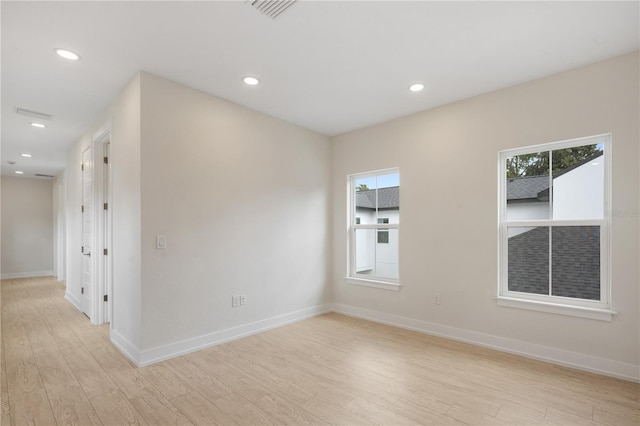 empty room with recessed lighting, a healthy amount of sunlight, visible vents, and light wood finished floors